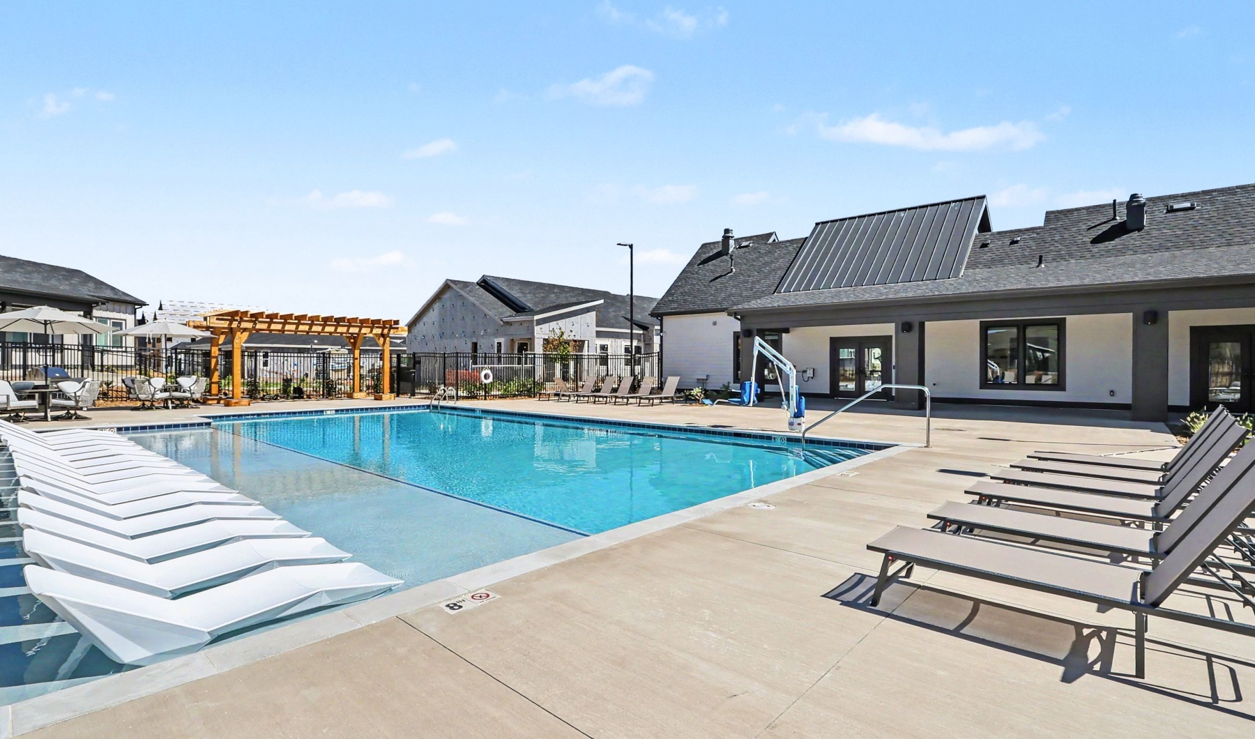 Resort style swimming pool with seating, barbecue grills and firepit