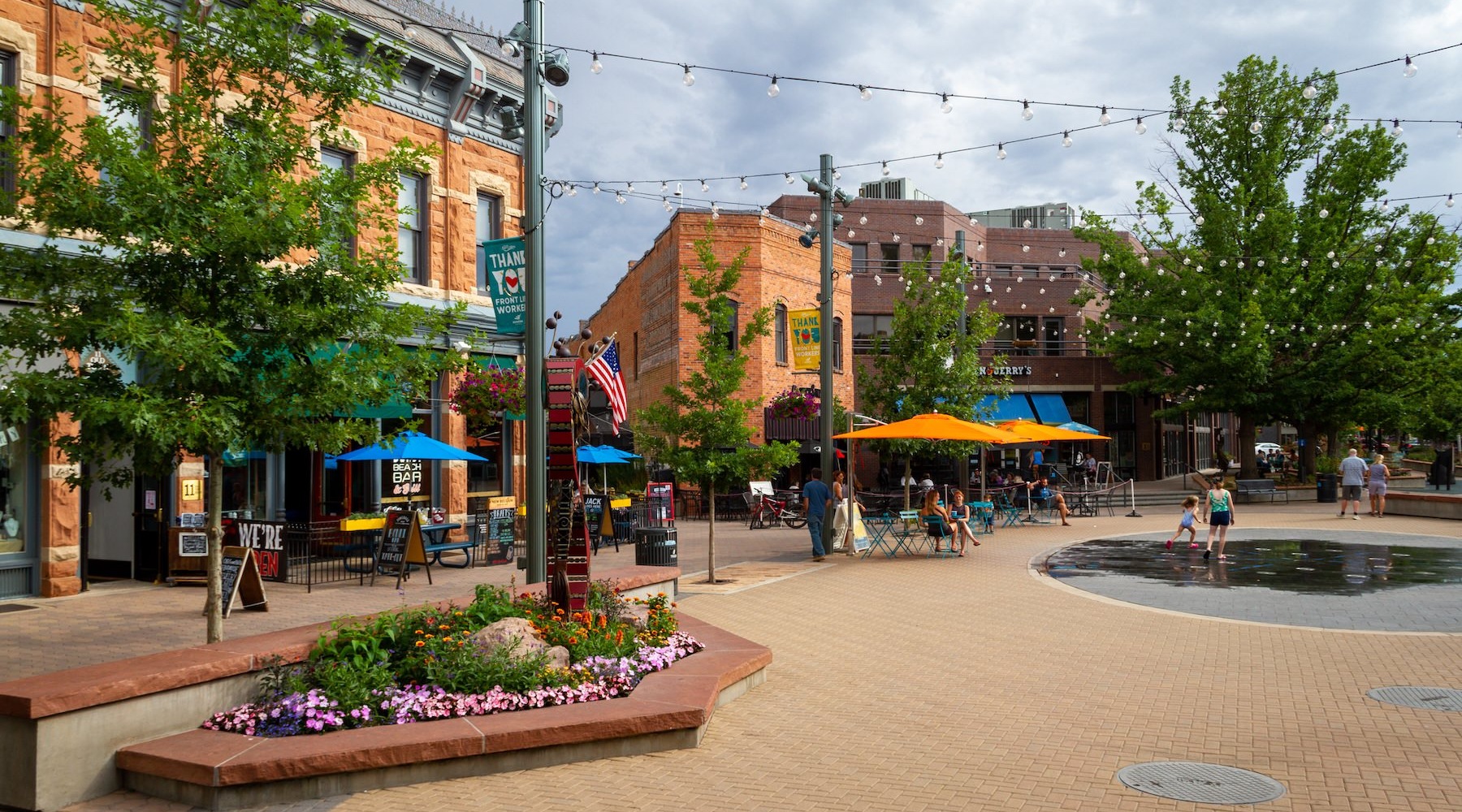 a plaza with people, trees and buildings